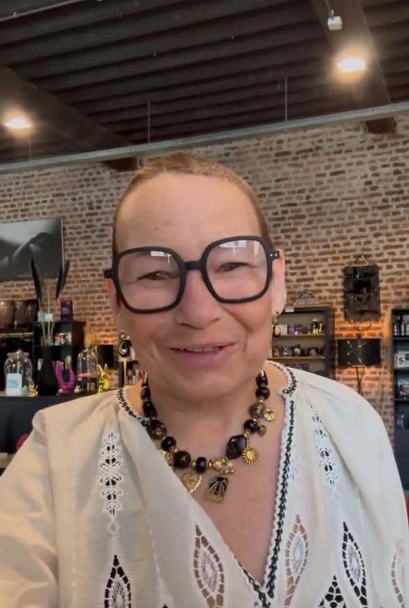 Chimène souriante dans sa boutique en blouse beige