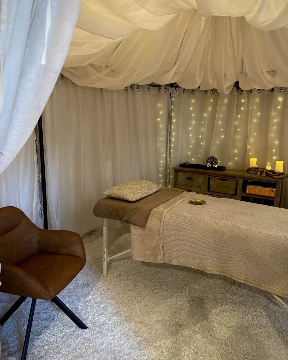 Table de massage installée sous les lumières chaleureuses de la tonnelle